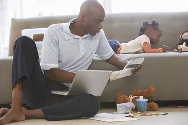 man on computer daughter on couch