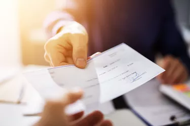 Businessperson Hands Giving Cheque