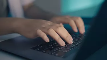 Doctor's hand typing on laptop