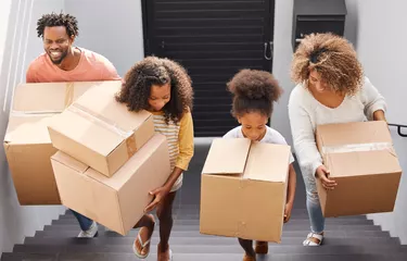 Shot of a family carrying boxes into their new home