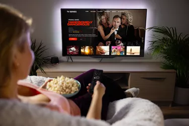Woman watching TV series and movies via streaming service at home