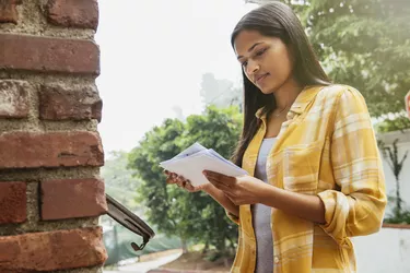 Woman reading mail at mailbox