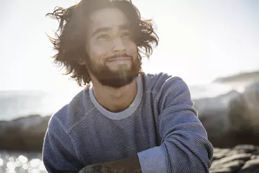 Portrait of young man at beach on windy day