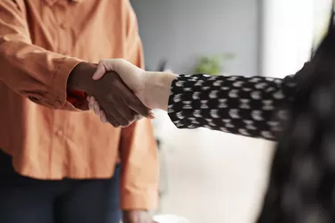 Business executives shaking hands at workplace