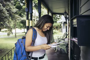 Teenage girl receiving letter of acceptance for college in mail