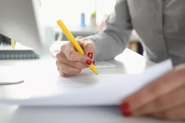 Woman hand holds pen and signs document