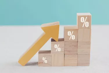 Wooden blocks with percentage sign and arrow up, financial growth, interest rate increase, inflation concept