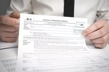 Businessman works with W-4 tax form and calculator
