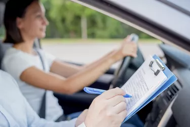 Instructor and young female student, driving lesson