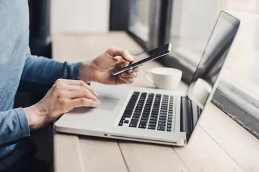 Young man using laptop computer and smart phone