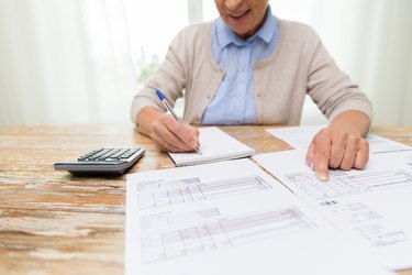 Is Pension Considered Earned Income?       senior woman with papers and calculator at home