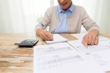 Is Pension Considered Earned Income?       senior woman with papers and calculator at home
