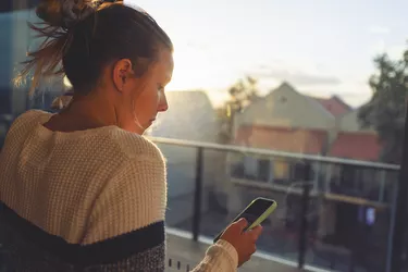 Woman looking through the window at sunset.