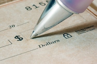 Super close-up photo of a ballpoint pen, and a bank check