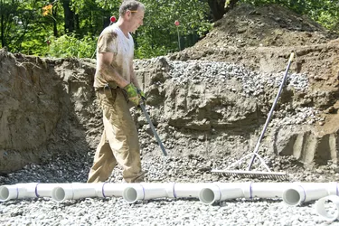 Worker holding level during leachfield construction