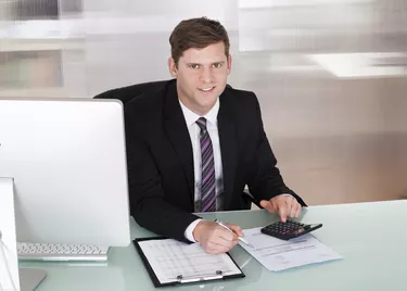 Happy young man calculating finances