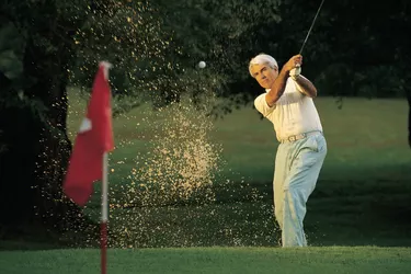 Golfer hitting out of sand trap