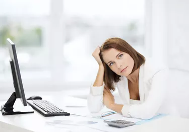 woman with computer, papers and calculator
