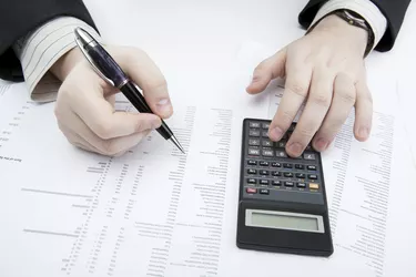businessman holding a pen and counts the budget