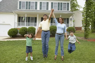 Family jumping together in front yard