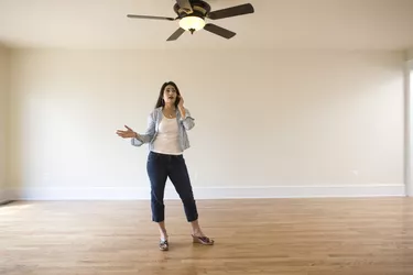 Woman on cell phone in empty room of new home