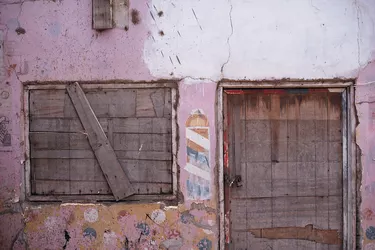 an old and abandoned building_s window and doorway have been boarded up using wood