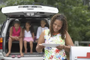 Young woman taking mail out of the mailbox