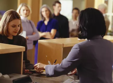 Woman taking money from bank teller in bank