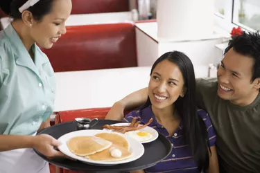 Asian couple being served food at diner