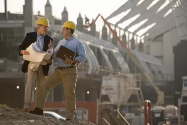 Architects with blueprints at construction site