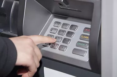 Woman pressing number button on ATM machine