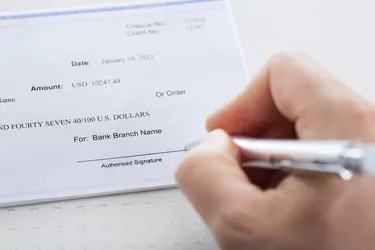 Hand With Pen Over Checkbook