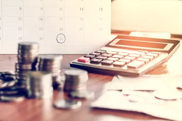 note, coins, banks, calculator on table